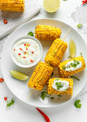 Grilled sweet corn with white mexican sauce, chilli and lime. healthy summer food