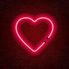Neon tubes in the shape of a heart isolated on a brick wall background. Sign of love.