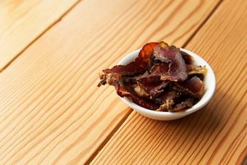 Biltong (dried meat) on a wooden board, this is a traditional food snack that can be found in South...