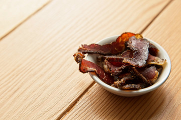 Biltong (dried meat) on a wooden board, this is a traditional food snack that can be found in South Africa.