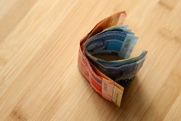South African money on a wooden table top. 