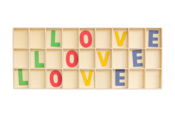 Top view of colorful wooden alphabet letters with love wording in a square wooden box isolated on white background. Clipping path inside.