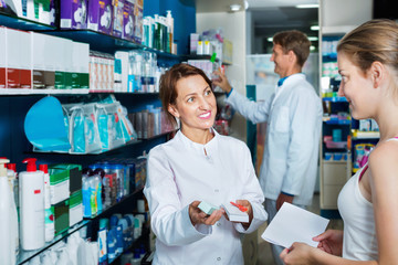 Smiling female pharmacist wearing uniform working