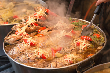 Cyprinidae fish boiled cooking with sauce at marketplace.

