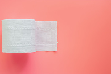 Tissue or toilet paper roll on pink background with copy space for wiping clean. Flat lay and top view image.