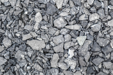 Grey ground stone rubble background of many small stones.