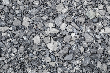 Grey ground stone rubble background of many small stones.