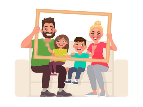 Family portrait. Dad, mom, son and daughter sitting on the couch, holding a picture frame