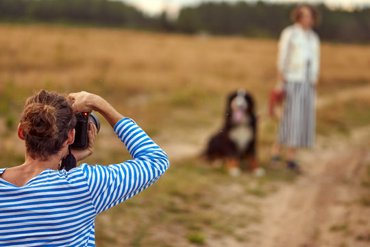 the girl is walking with a dog breed. photographer takes pictures of a girl with a dog. photo shoot in nature