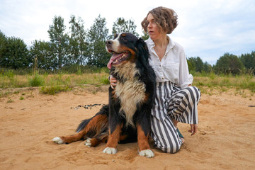 the girl is hugging a big dog. beautiful mistress and dog of the breed sennenhund