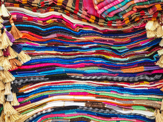 Colorful arabic rugs piled up at the market in Morocco