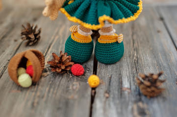 The knitted toy on a wooden table. Handmade. It can be used as a background