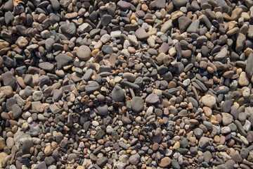 Natural pebble rocks in real natural riverside as texture background