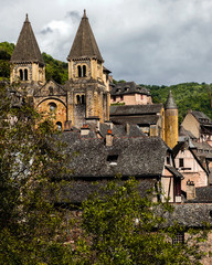 Conques medieval village cityscape with grey clouds, Aveyron, France