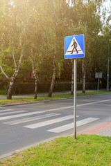 Crosswalk or zebra crossing and street sign.