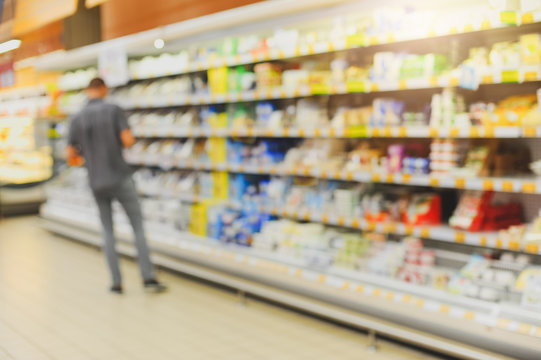 Blurred product shelves in the supermarket. Defocused background of store.