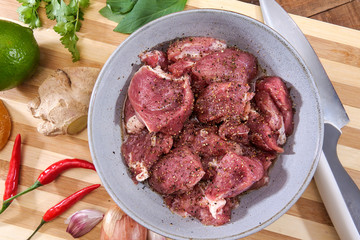 Pork medallions for Vietnamese dish preparation on a wooden board