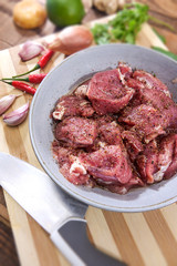 Pork medallions for Vietnamese dish preparation on a wooden board