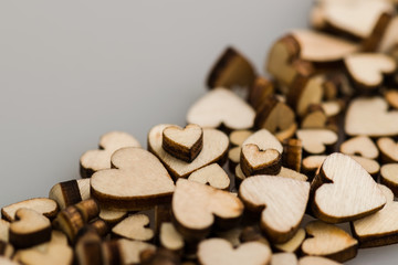 Many small wooden hearts on a blurred background