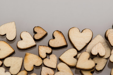 Many small wooden hearts on a blurred background