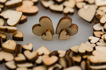 Many small wooden hearts on a blurred background