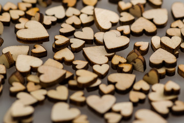 Many small wooden hearts on a blurred background