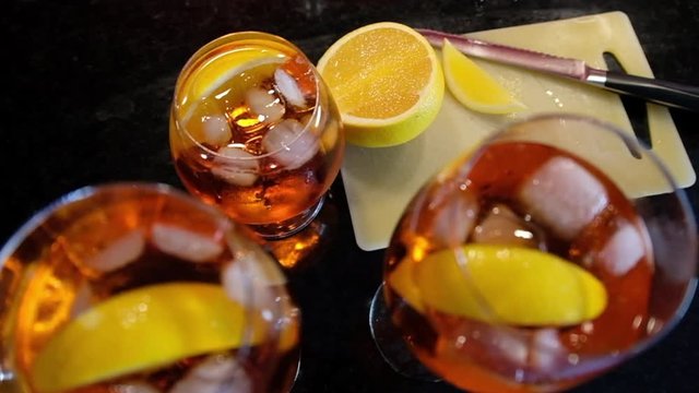Freshly sliced orange in Aperol spritz drink in Slow motion