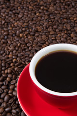 Obraz na płótnie Canvas Red coffee cup with coffee beans.