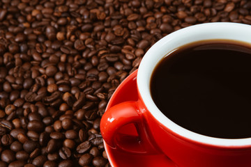 Red coffee cup with coffee beans .