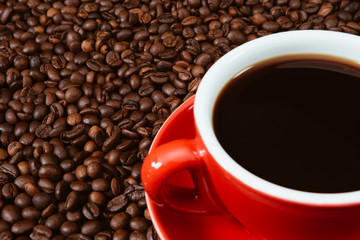 Red coffee cup with coffee beans .