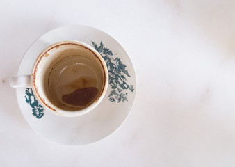 Empty coffee cup with saucer on white marble table
