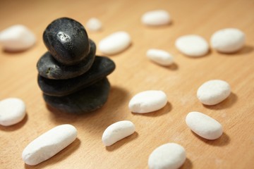 Spa massage still life   balancing black stones and white pebbles