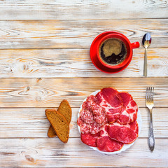 sliced jerky on a plate on a wooden background
