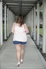 Naklejka premium Asian pretty fat woman pose walking on walkway.