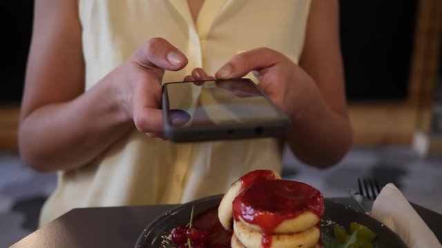 Smartphone food photo - female takes pictures of her breakfast plate of cheese pancakes