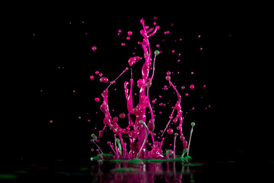 Magenta, pink  paint, ink splash on black background