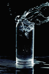 Ice splashing into water glass