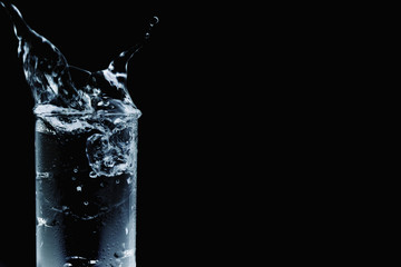 Ice splashing into water glass
