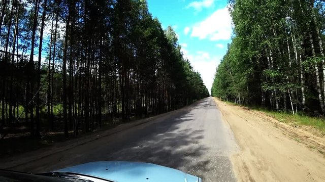 Bad road conditions, broken asphalt. Driving a car on a road.