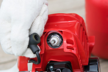 master of maintenance of gasoline tools, checks the spark plug, close-up