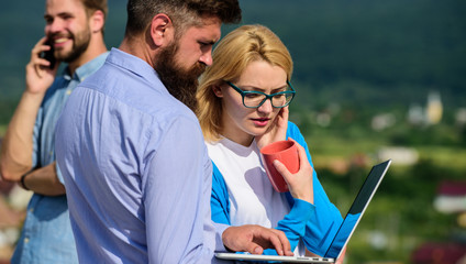 Coffee break concept. Colleagues pay attention screen laptop while man talking phone. Colleagues...