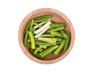 Chopped green onions in wooden bowl on white background top view.