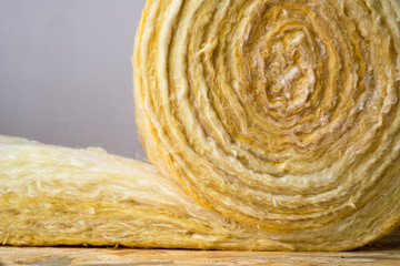 roll of mineral wool lying on the wooden floor