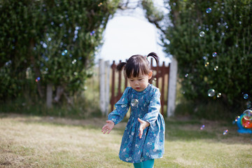 baby girl play bubble at Summer garden