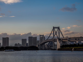 Obraz premium It is a beautiful sunset seen from the seaside. The bridge is a famous Rainbow Bridge in Japan.This place is Odaiba Beach Park in Tokyo, Japan. 