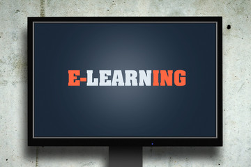 The inscription is E-Learning on the monitor screen against the background of the concrete wall. Education.