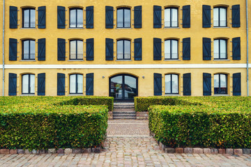 Beautiful facade of the building with windows and a beautiful lawn. Architecture.