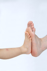 小さな足と大きな足、足の大きさを比べる仲良し親子のイメージ