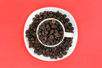 Coffee bean white ceramic cup saucer on red color background