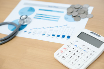 Stack of money coins with stethoscope checking